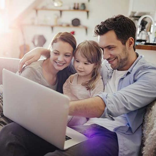 Family sitting together with a laptop 